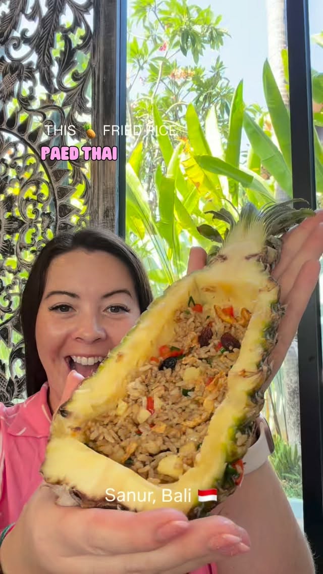 Zen holding up a carved pineapple filled with Thai fried rice at Paed Thai in Sanur, Bali.