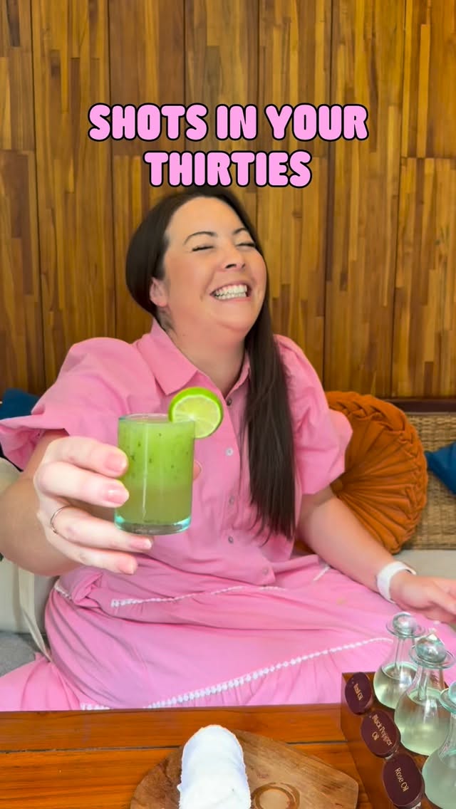 Zen smiling while holding a green welcome shot glass topped with a lime slice.